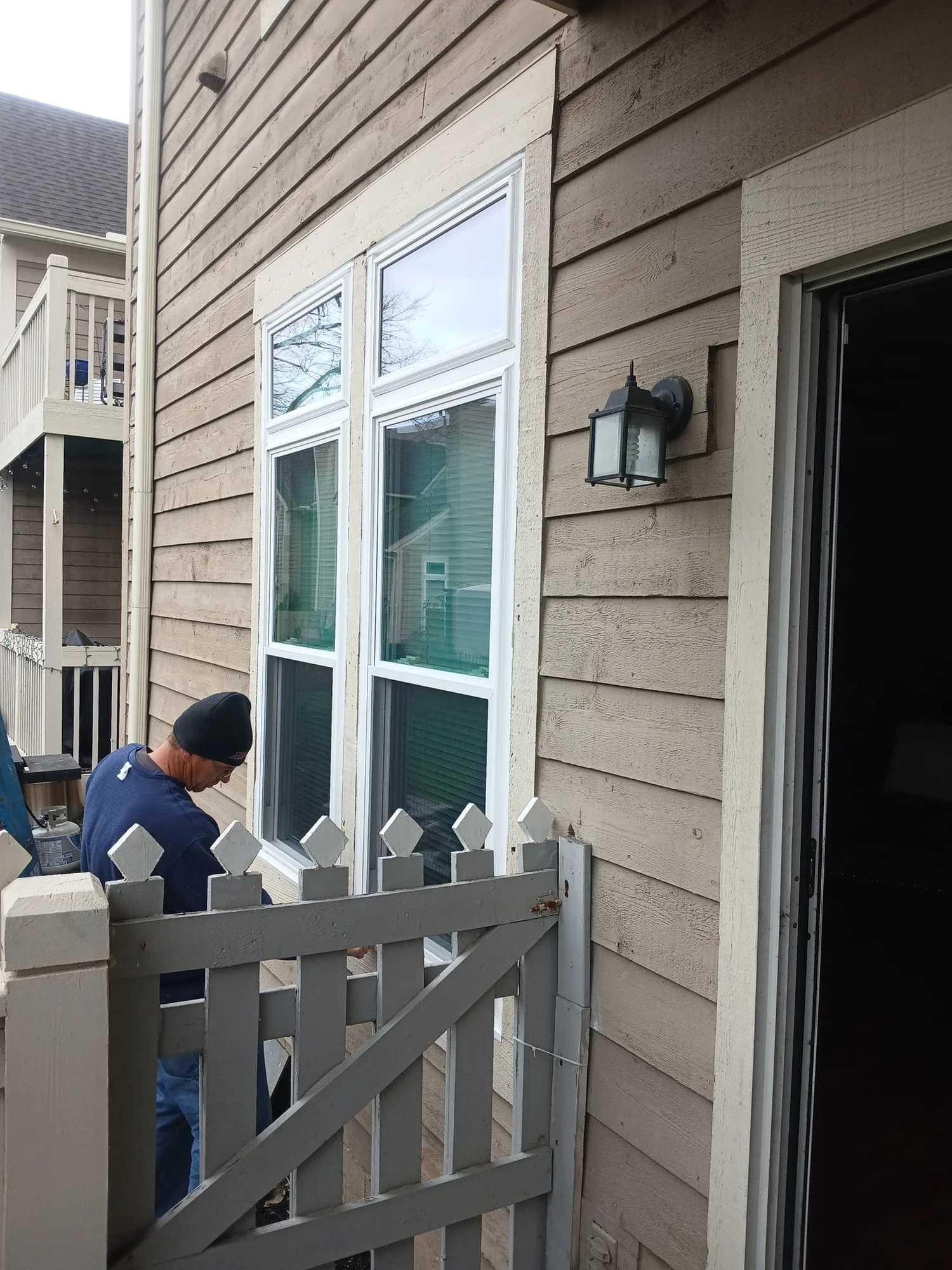 Exterior wall with newly installed windows and a lamp.